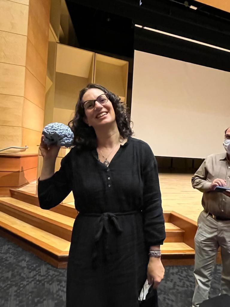 A picture of Cheryl Kaiser holding a 3D printed model of her brain. 